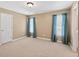 Carpeted bedroom filled with natural light with white door and blue curtains at 1232 Everton Pl, Cumming, GA 30041