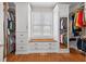 Spacious walk-in closet with custom shelving, built-in drawers, a window seat and hardwood floors at 1232 Everton Pl, Cumming, GA 30041