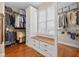 Well-organized walk-in closet featuring custom storage solutions, a window seat, and hardwood floors at 1232 Everton Pl, Cumming, GA 30041