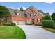 Attractive red brick home with a multi-car garage and a landscaped front yard at 1232 Everton Pl, Cumming, GA 30041