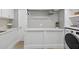 Bright laundry room with white cabinetry, quartz countertop, and modern washer and dryer at 1232 Everton Pl, Cumming, GA 30041