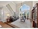 Bright living room with a vaulted ceiling, large windows, and elegant staircase at 1232 Everton Pl, Cumming, GA 30041