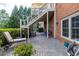 Brick home with covered patio perfect for outdoor living, complete with lounge chair and access to upper level at 1232 Everton Pl, Cumming, GA 30041