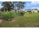 A sprawling backyard with green space, planting beds, and a fire pit area, great for outdoor activities and relaxation at 1250 Timber Walk Dr, Loganville, GA 30052