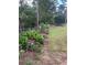 Landscaped backyard featuring flowerbeds with vibrant greenery, flowering plants, and a partial chain-link fence at 1250 Timber Walk Dr, Loganville, GA 30052
