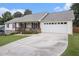 Ranch-style home showcasing a spacious driveway leading to a two-car garage and front porch at 1250 Timber Walk Dr, Loganville, GA 30052
