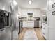 Bright kitchen featuring stainless steel appliances, white cabinets, and light wood flooring at 1250 Timber Walk Dr, Loganville, GA 30052