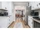 Spacious kitchen with white cabinets and wood flooring with open view to the dining area at 1250 Timber Walk Dr, Loganville, GA 30052
