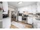 Modern kitchen features stainless steel appliances, white cabinets, and granite countertops at 1250 Timber Walk Dr, Loganville, GA 30052