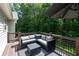 Back deck with outdoor sectional seating with gray cushions and an umbrella for shade at 19 Autumn Ne Pl, White, GA 30184