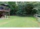 Spacious backyard with green grass and wooden privacy fence and stairs to a deck at 19 Autumn Ne Pl, White, GA 30184