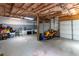 Unfinished garage with multiple overhead doors, lawn equipment, and ample storage space at 19 Autumn Ne Pl, White, GA 30184