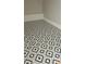 Close-up of modern geometric patterned tile flooring in a room with gray walls and white trim at 2085 Dellwood, Decatur, GA 30032
