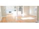 Sunlit living room with hardwood floors flowing into a modern kitchen featuring white cabinets and stainless appliances at 2085 Dellwood, Decatur, GA 30032