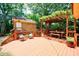 Spacious back deck features a wooden pergola, seating area, and an additional structure in a lush backyard setting at 27 S Avondale Rd, Avondale Estates, GA 30002