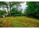 Spacious backyard with a fire pit, lush moss, and mature trees providing ample shade at 27 S Avondale Rd, Avondale Estates, GA 30002