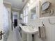 Comfortable bathroom featuring a pedestal sink, stylish fixtures, wainscoting, and a shower with a floral curtain at 27 S Avondale Rd, Avondale Estates, GA 30002