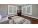 Cozy bedroom featuring hardwood floors, three double-hung windows, and a comfortable gray sofa at 27 S Avondale Rd, Avondale Estates, GA 30002