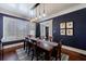 Elegant dining room with dark blue walls, hardwood floors, and stylish lighting fixture above the table at 27 S Avondale Rd, Avondale Estates, GA 30002