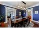 Stylish dining room featuring dark blue walls, white trim, and modern pendant lighting over a wooden table at 27 S Avondale Rd, Avondale Estates, GA 30002