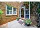 Charming front porch with brick exterior, arched doorway, potted flowers, and welcoming entrance at 27 S Avondale Rd, Avondale Estates, GA 30002
