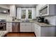 Bright kitchen showcases stainless steel appliances, granite counters, white cabinets, and natural lighting at 27 S Avondale Rd, Avondale Estates, GA 30002