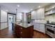 Open kitchen with white cabinets, stainless steel appliances, granite countertops, and a central island at 27 S Avondale Rd, Avondale Estates, GA 30002
