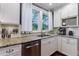 Close-up of kitchen area shows stainless steel appliances, granite countertops, and white cabinets at 27 S Avondale Rd, Avondale Estates, GA 30002