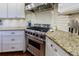 Bright kitchen with a stainless steel Viking range, granite countertops and white cabinetry at 27 S Avondale Rd, Avondale Estates, GA 30002
