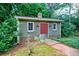 Charming shed with green siding, red door, and vintage-style lantern fixtures at 27 S Avondale Rd, Avondale Estates, GA 30002