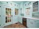 Butlers Pantry featuring custom cabinetry, wine refrigerator, and unique brick floors at 626 Elmwood Ne Dr, Atlanta, GA 30306