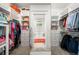 Spacious walk-in closet with custom shelving and storage solutions leading into bright, luxurious bathroom at 626 Elmwood Ne Dr, Atlanta, GA 30306