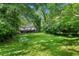 Large backyard view with lush grass and trees surrounding the property at 1556 Braeburn Se Dr, Atlanta, GA 30316
