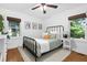 Cozy bedroom features a metal frame bed, two windows, hardwood floors and neutral decor at 1556 Braeburn Se Dr, Atlanta, GA 30316