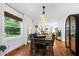 Bright dining room features a wooden table with black chairs, hardwood floors, and a view through a large window at 1556 Braeburn Se Dr, Atlanta, GA 30316