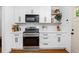 This remodeled kitchen offers white cabinets, stainless appliances, floating shelves and hardwood flooring at 1556 Braeburn Se Dr, Atlanta, GA 30316