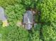 An aerial view of a quaint home with gray shingles nestled among mature trees, providing a private, wooded setting at 200 Zachary Woods Nw Pt, Marietta, GA 30064
