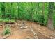 Landscaped backyard with a brick fire pit, rock wall and lush trees at 200 Zachary Woods Nw Pt, Marietta, GA 30064