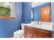 Charming powder room with a wood vanity, white sink, blue wallpaper and a window at 200 Zachary Woods Nw Pt, Marietta, GA 30064