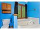 Soaking tub with window and dark curtains, set against vibrant blue walls in this stylish bathroom at 200 Zachary Woods Nw Pt, Marietta, GA 30064