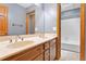Bathroom vanity with double sinks, wood cabinets, and a tub and shower in the background at 200 Zachary Woods Nw Pt, Marietta, GA 30064