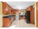 Traditional kitchen with wooden cabinets, black countertops, white appliances and tile floors at 200 Zachary Woods Nw Pt, Marietta, GA 30064