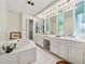 Bright bathroom with a soaking tub and multiple sinks with large mirrors at 285 Glen Lake Dr, Atlanta, GA 30327