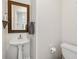 Bright powder room features a pedestal sink with decorative mirror, and neutral walls at 285 Glen Lake Dr, Atlanta, GA 30327