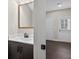 This bathroom features a dark wood vanity with a decorative mirror and doorway to the garage at 338 Mount Zion Rd, Oxford, GA 30054
