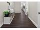 This hallway features wood floors, a decorative bench, and doorways to other rooms at 338 Mount Zion Rd, Oxford, GA 30054