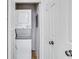 Hall laundry closet with a stacked white washer and dryer; includes shelving unit at 3655 Habersham Ne Rd # B-254, Atlanta, GA 30305
