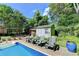 Enjoy the backyard pool area with lounge chairs and a storage shed surrounded by mature trees and landscaping at 4562 Lucerne Valley Sw Rd, Lilburn, GA 30047