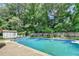 Enjoy the backyard oasis with a sparkling in-ground pool, lush greenery, and a convenient storage shed at 4562 Lucerne Valley Sw Rd, Lilburn, GA 30047