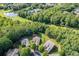 Serene aerial view showcasing a home near a tranquil lake, golf course, and tennis courts, surrounded by lush trees at 601 Laurel Xing, Canton, GA 30114